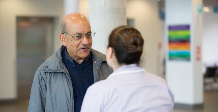 Man talking to health professional in waiting room