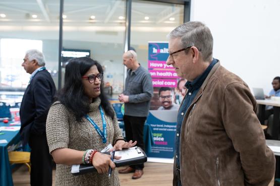 woman talks to man at healthwatch event